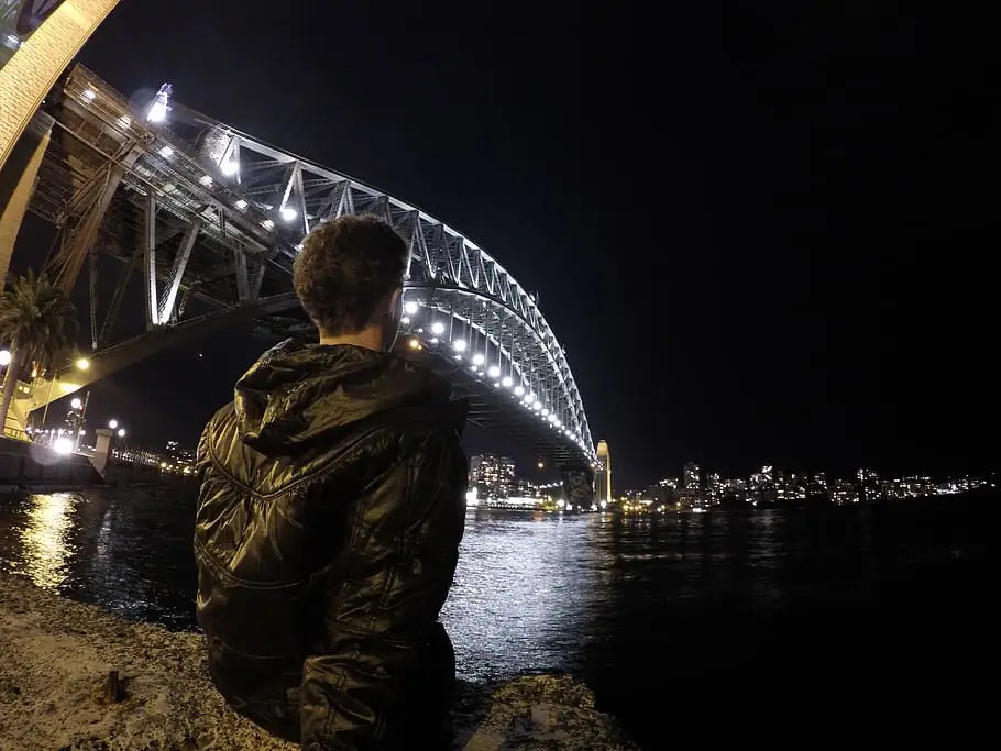 Couple taking a selfie on a bridge with a cityscape backdrop